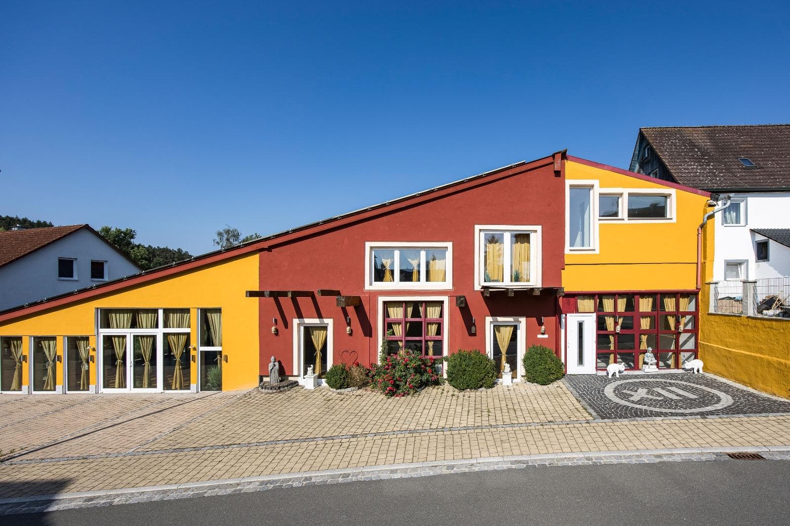 Die rot-gelbe Fassade von Punkt XII aus der Vogelperspektive