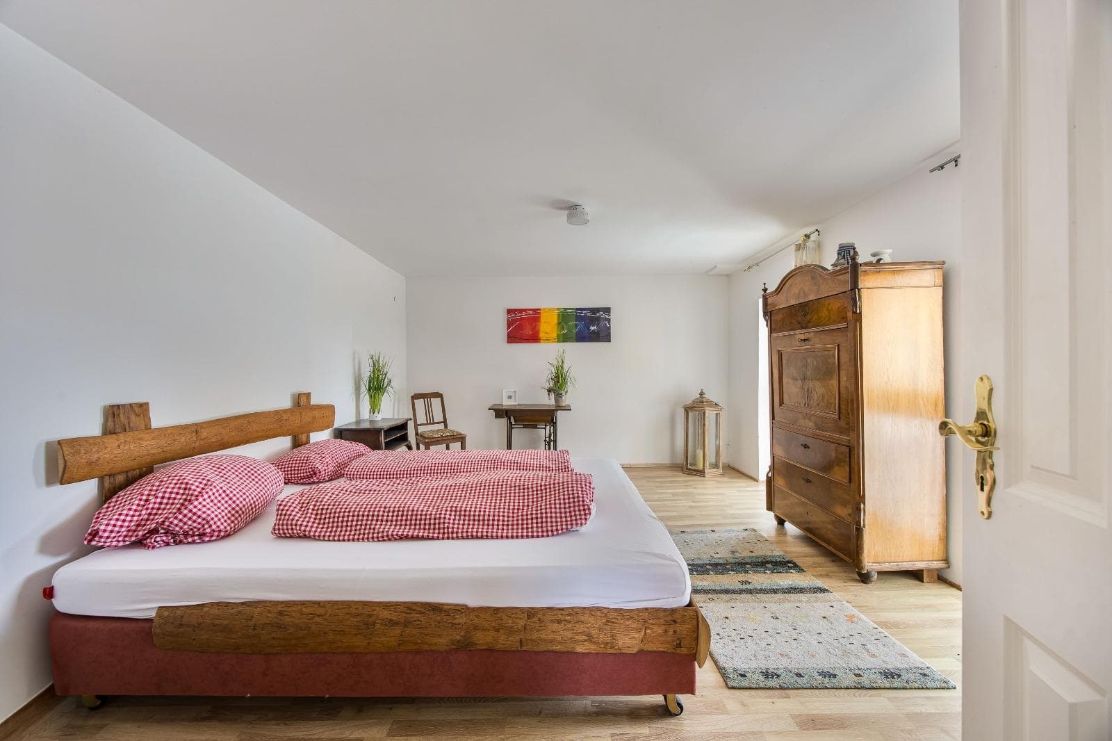 Gemütliches Gästezimmer mit Holzmöbeln und warmer Bettwäsche bei Punkt XII
