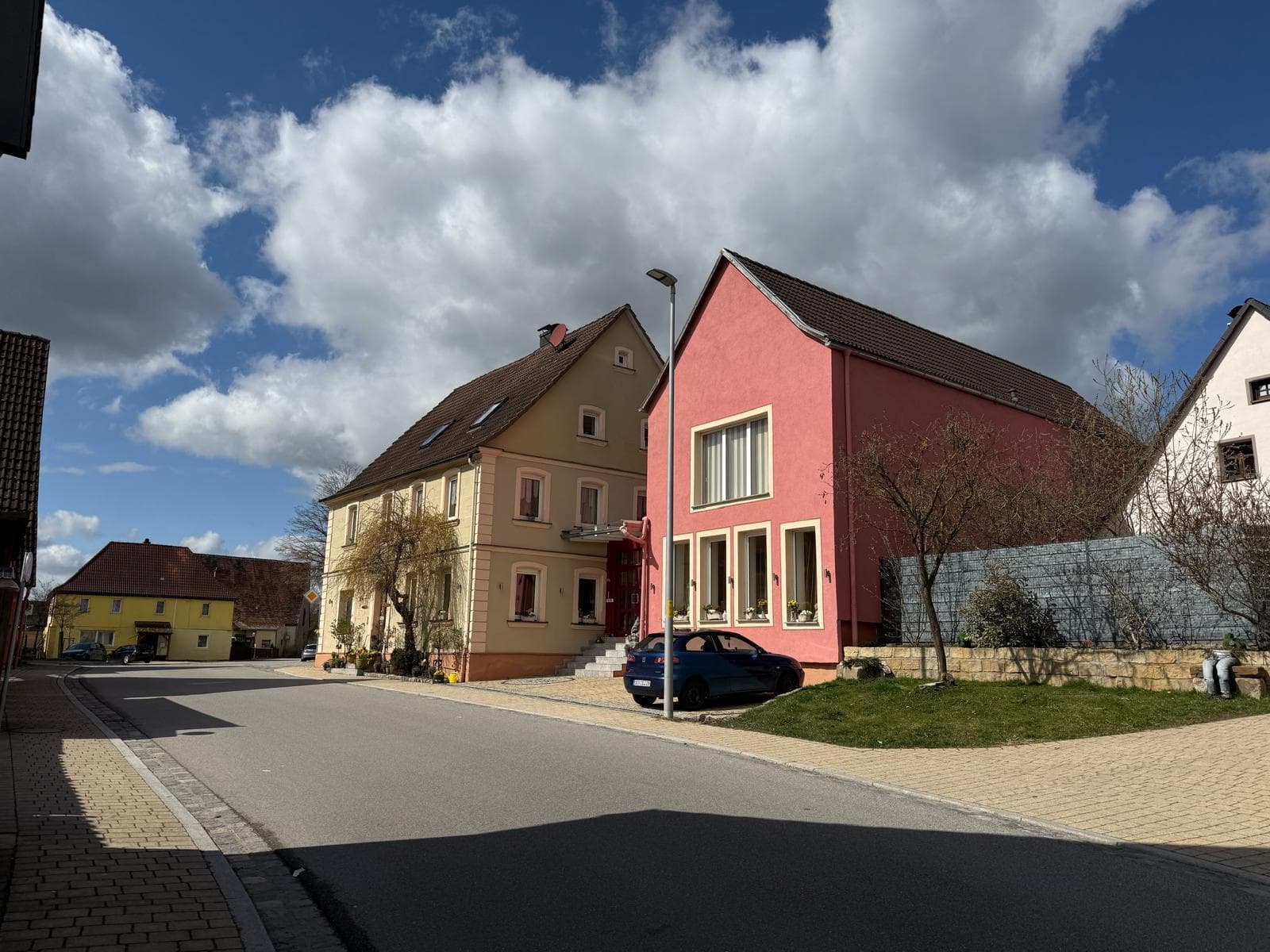The quiet village street of Oberrimbach with terracotta houses under a blue sky