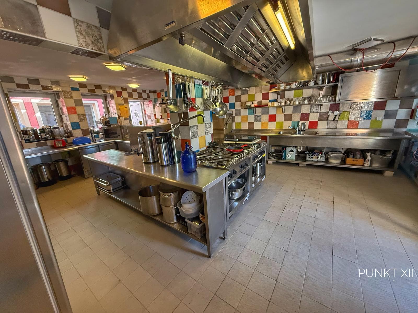 Large communal kitchen with colourful tiles at Punkt XII