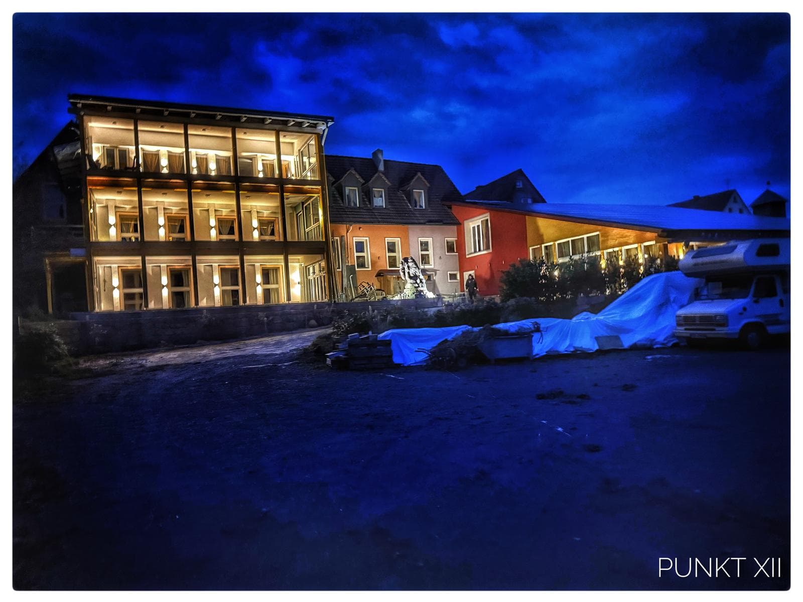 Der gläserne Wintergarten leuchtet abends golden zur blauen Stunde