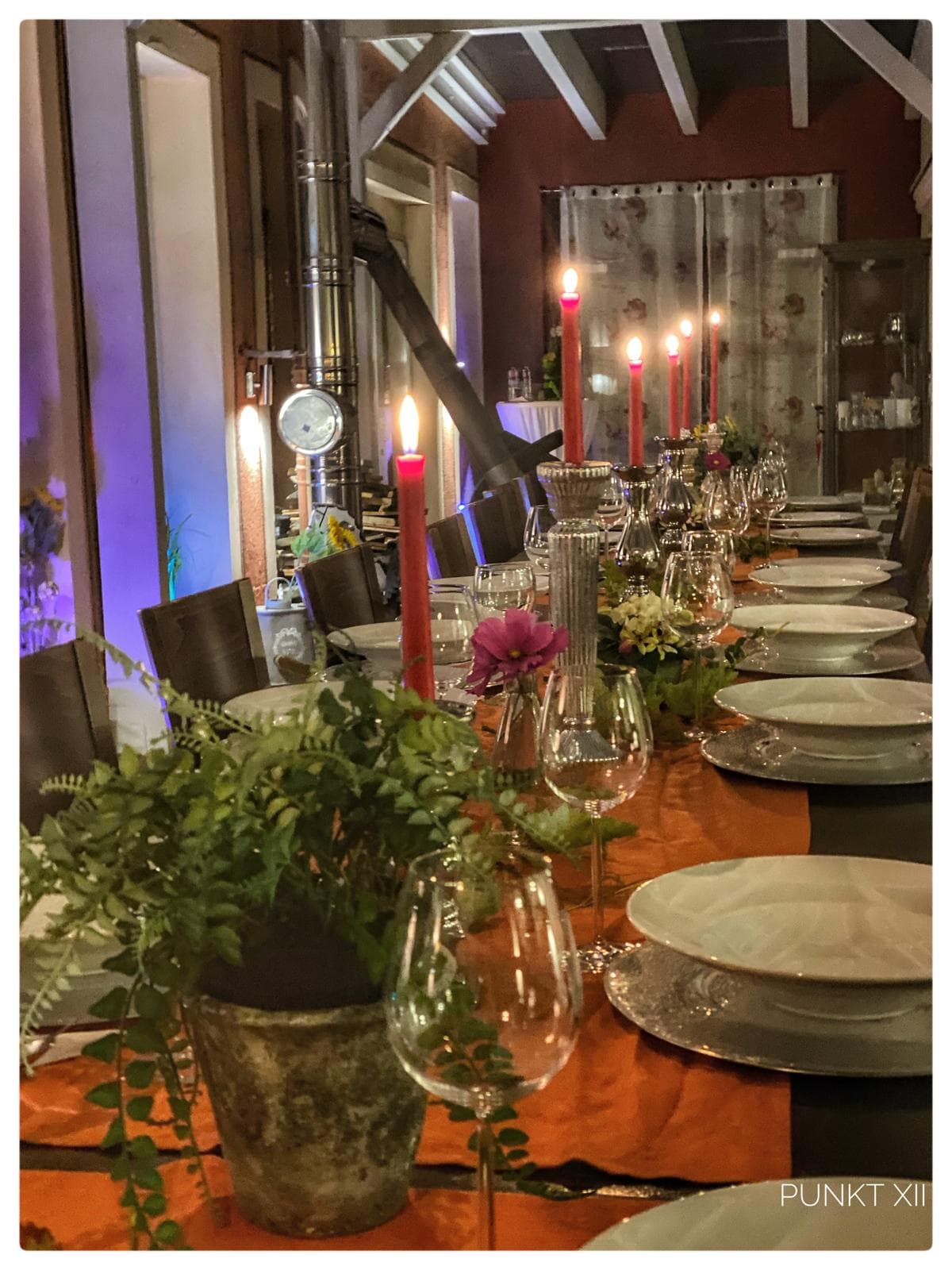 Festlich gedeckte lange Tafel mit Kerzen im Wintergarten von Punkt XII